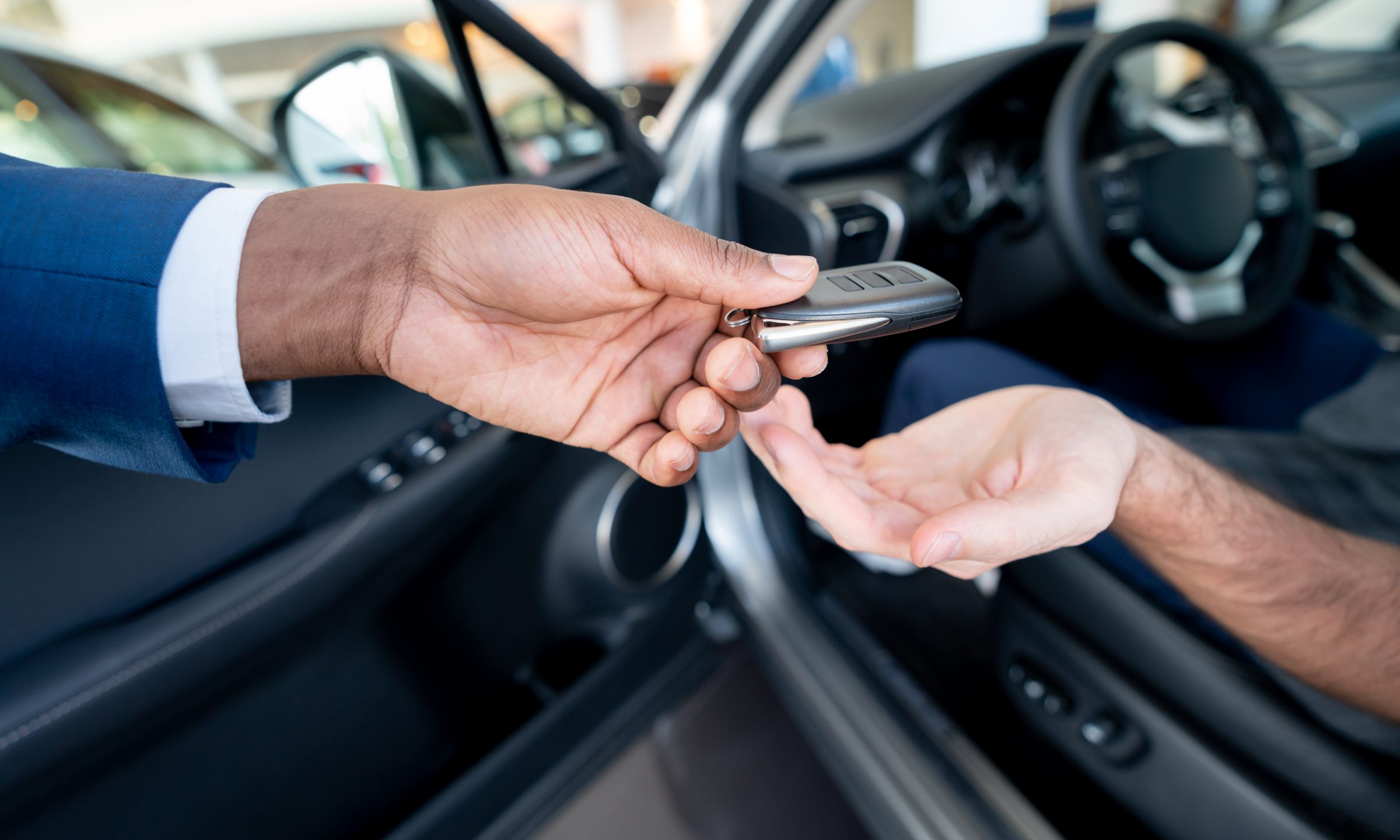 male handing a female car keys can only see their hands
