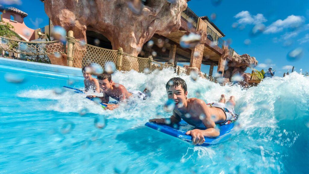 Picture of three boys riding a waver on a boogie board at a family resort