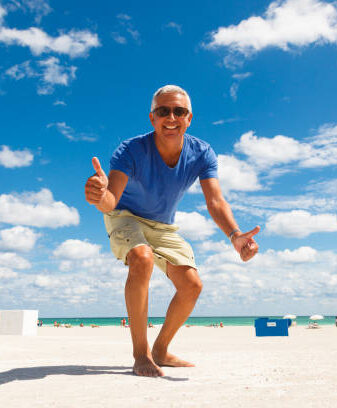 guy on beach with thumbs up smiling