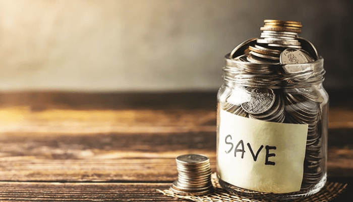 jar of coins with save on yellow sticky note inside of jar