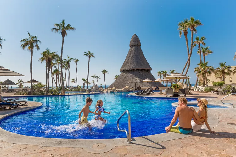 Picture of family playing in blue water pool in the caribbean in an all inclusive resort