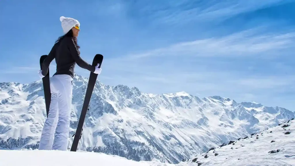 Aspen colorado top of mountain woman looking out holding skis