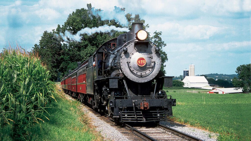 Strasburg railroad old #476 steam rolling coming thru a corn field