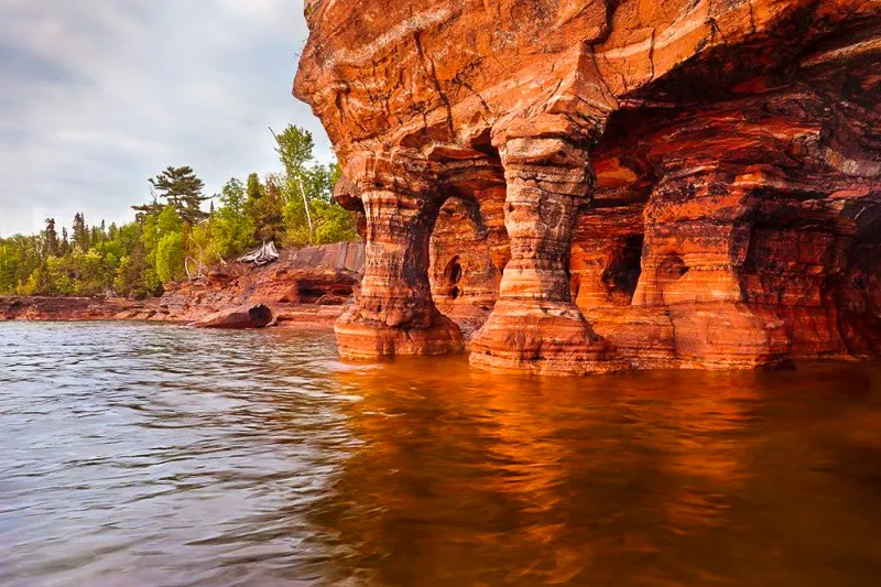 minnesota apostel island in water looking at shoreline of erroded clif sides secret destinations