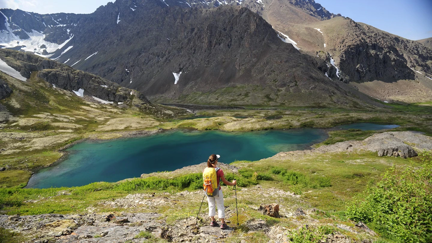 Anchorage Alaska Hiker on top of ridge looking at lake and mountain