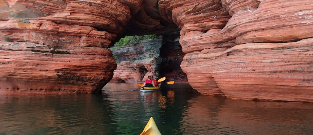 apostle island minnesota budget friendly weekend kayaks going in caves in cliff wall