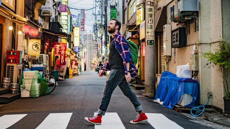 Portrait of man walking on zebra crossing on Tokyo street